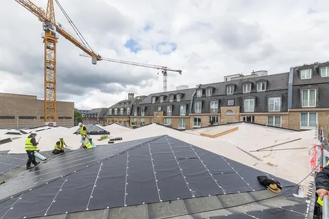 Couvreurs au travail sur une grande sous-toiture