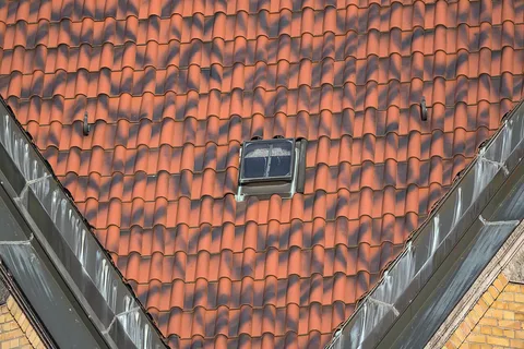 Fenêtre de toit encastrée dans une couverture en tuiles