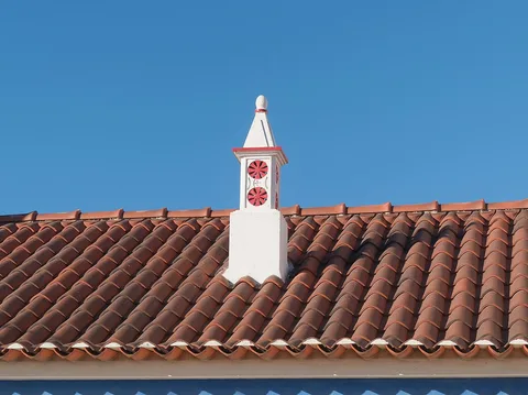 Souche de cheminée blanche sur une couverture en tuiles